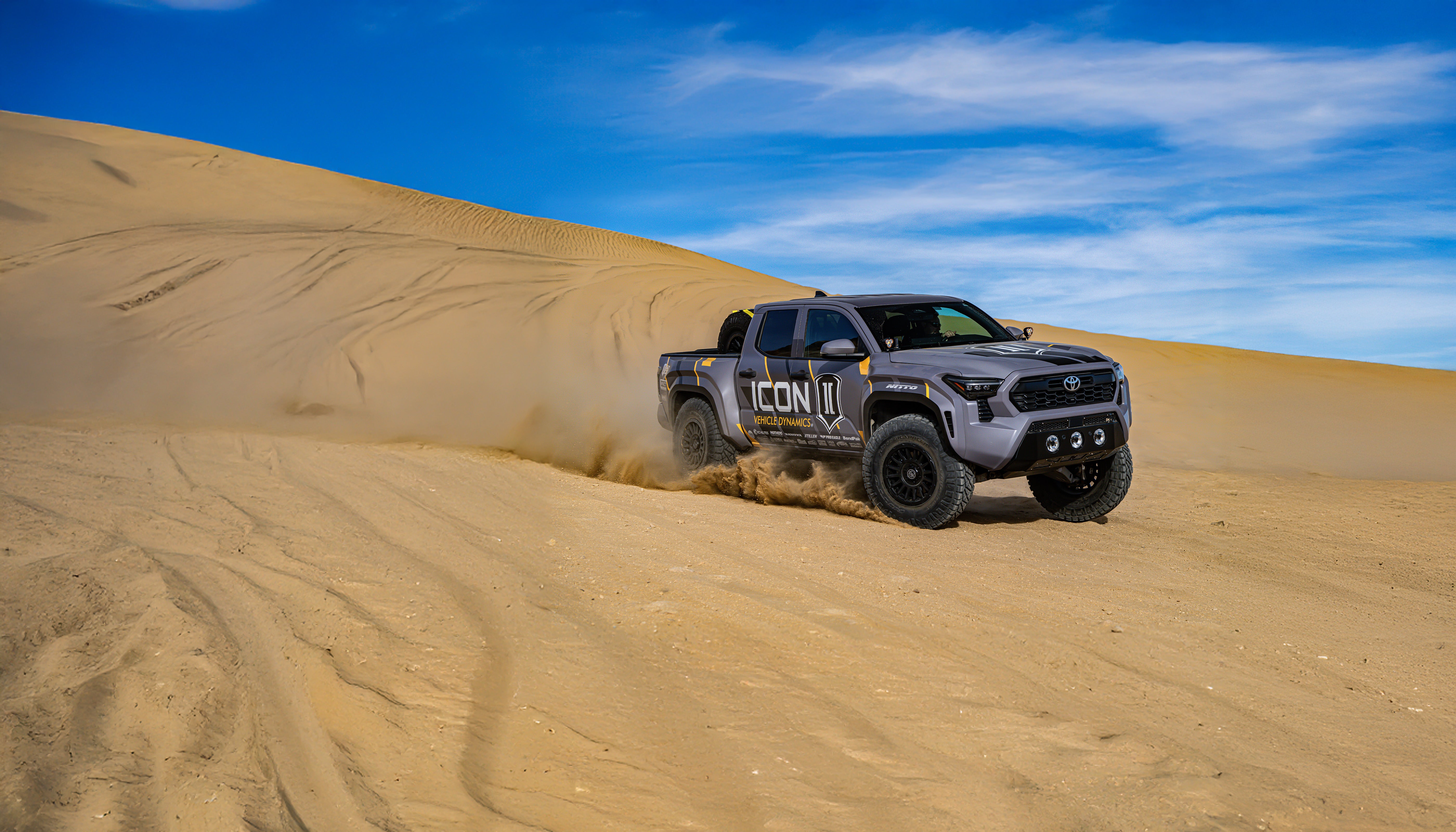ICON-equipped 2024 Toyota Tacoma climbing a sand dune
